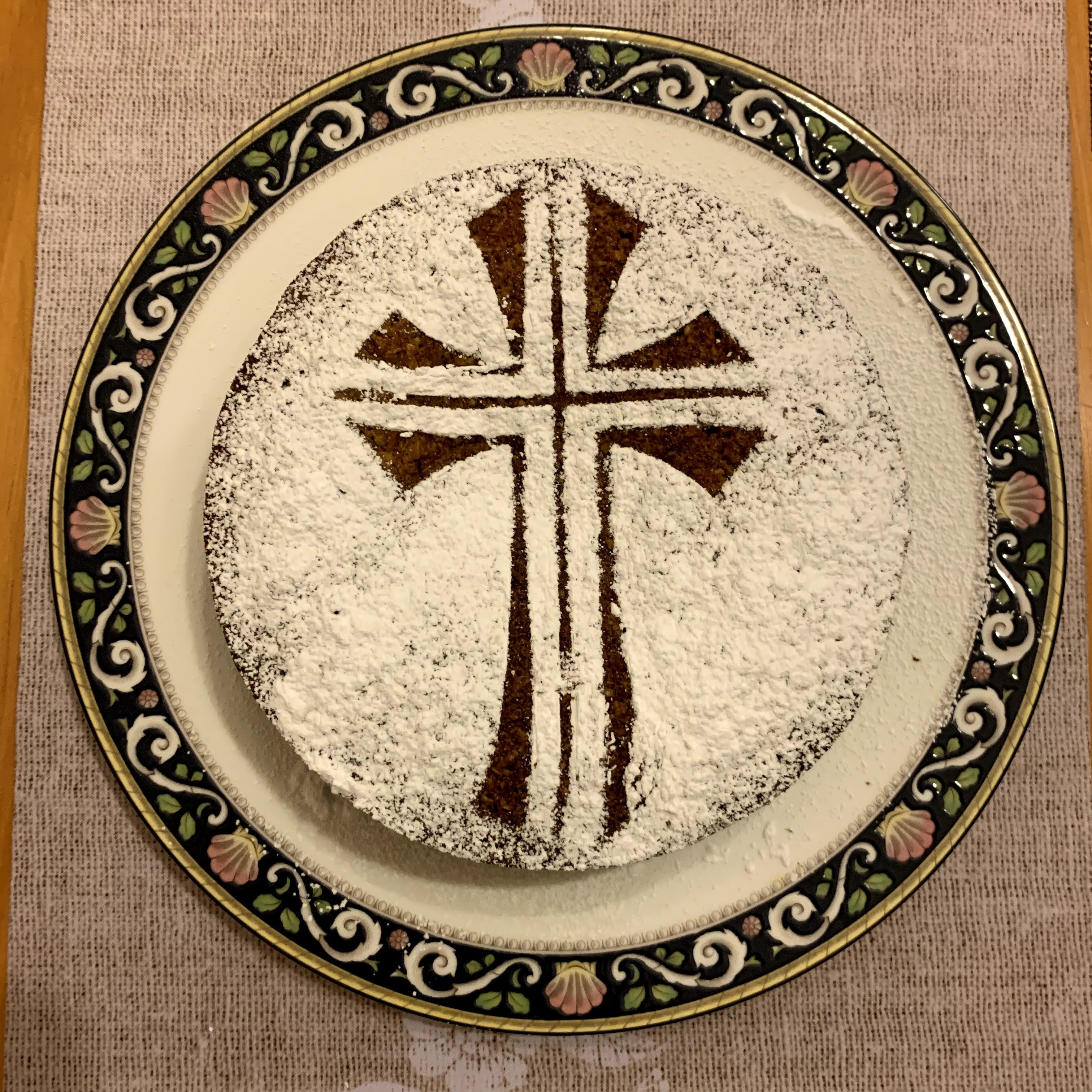 carrot cake with icing sugar in the shape of a cross
