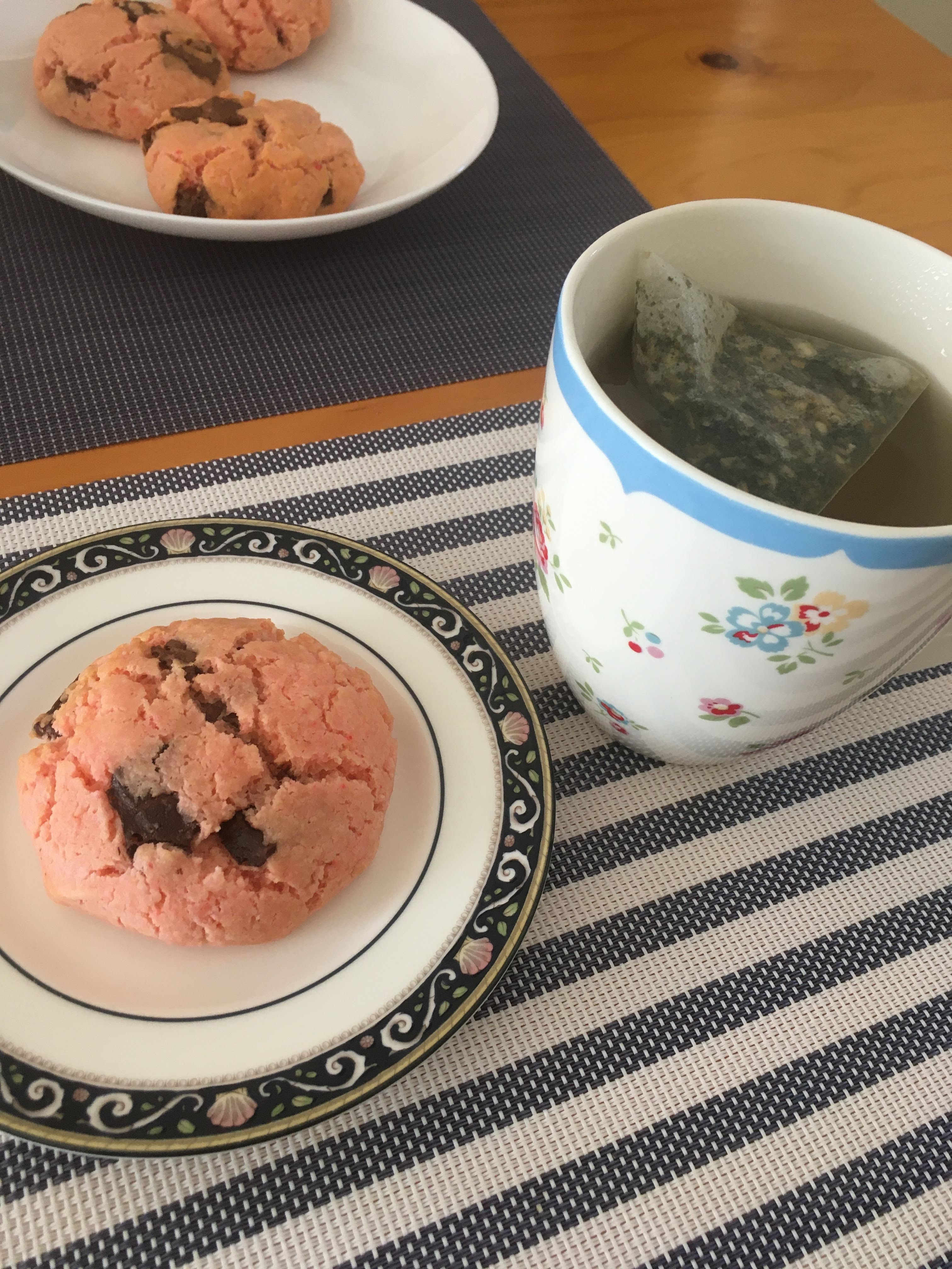 pink biscuits with chocolate chips and a cup of tea