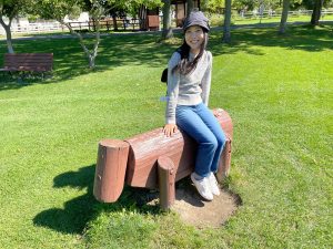 Megumi sitting on a bench shaped like a cow