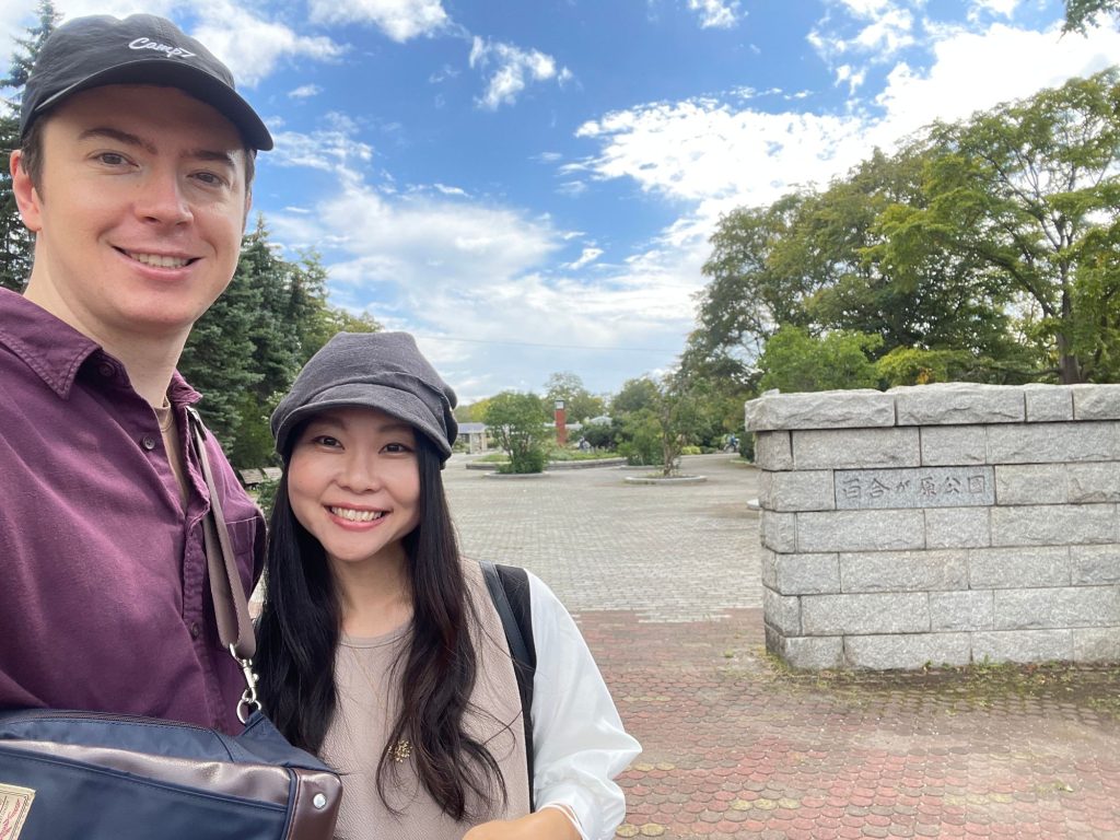 Megumi and Benjamin standing in front of Yurigahara Park's main entrance